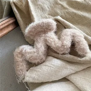 Gros plan détaillé sur une pince à cheveux ondulée en peluche douce de couleur café clair