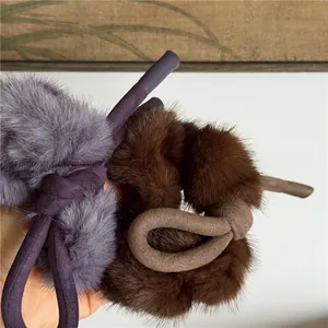 Gros plan de chouchous en fausse fourrure douce avec nœuds mats en violet et marron
