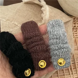 Set di tre fermagli per capelli in lana intrecciata nera, marrone e grigia con bottoni d'oro