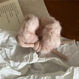 Gros plan d'un chouchou en fausse fourrure rose avec un élégant nœud beige décoratif
