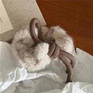 Détail d'un chouchou en fausse fourrure avec nœud marron sur papier froissé