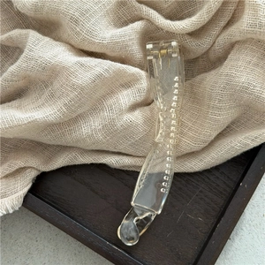 Macro detail of transparent acrylic banana hair clip with metal spring and inner teeth