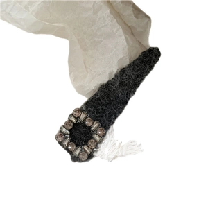 Elegant black plush hair clip with square rhinestones on a white textured background
