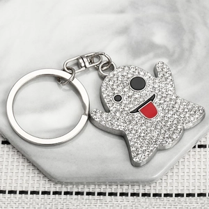 Sparkly rhinestone ghost keychain with red tongue detail on marble and fabric background
