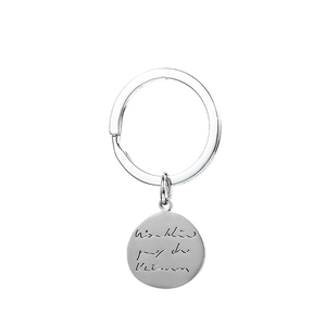 Macro shot of silver stainless steel keychain featuring a hand-engraved custom metal pendant
