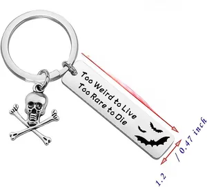 Close-up of stainless steel keychain with skull charm and Too Weird to Live engraved tag