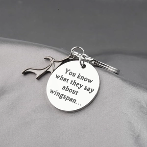 Vintage stainless steel bat wing keychain with engraved quote on a silver tag