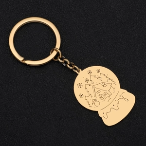 Golden stainless steel snow globe keychain with winter cabin and snowflake pattern