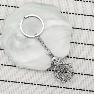 Vintage silver skeleton hand metal keychain on a white marble tray for men