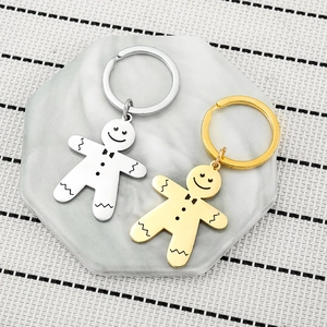 Close-up of gold and silver gingerbread man keychains on a marble display stand