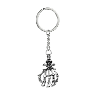 Detail of gothic skull palm keychain with vintage metal finish and skeleton hand design