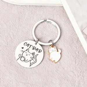 Detail shot of the stainless steel Cat Dad keychain with white enamel kitten pendant