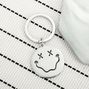Minimalist stainless steel hollow smiley face keychain with shiny silver finish on stone