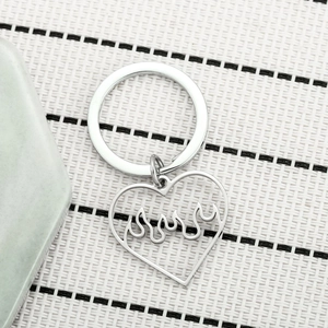 Detailed macro view of heart-shaped hollow flame keychain pendant in polished silver finish