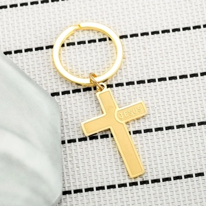 Polished gold stainless steel cross keychain featuring engraved JESUS text on a metal ring