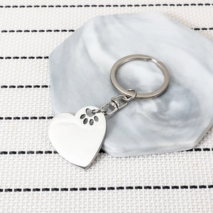 Polished stainless steel heart keychain with cutout paw print for pet lovers