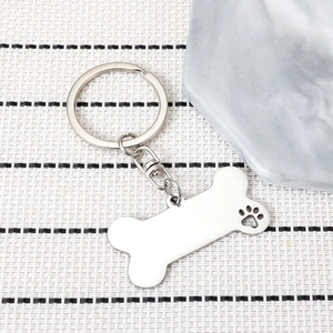 Polished silver bone-shaped stainless steel keychain with a hollow pet paw cutout