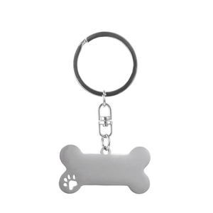 Detailed macro view of bone-shaped stainless steel keychain with hollow paw print pattern
