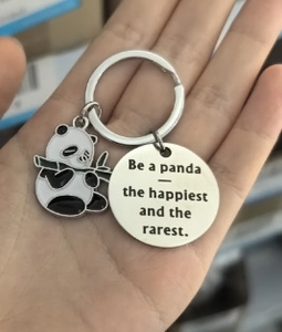 Detail of silver panda keychain featuring engraved quote pendant and cute bamboo charm