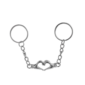 Détail de porte-clés couple magnétique en métal argenté formant un cœur de mains