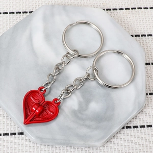 Close-up of interlocking heart-shaped metal keychains on a white marble tray