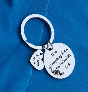 Détail macro du porte-clés coeur en acier inoxydable gravé pour maman sur tissu