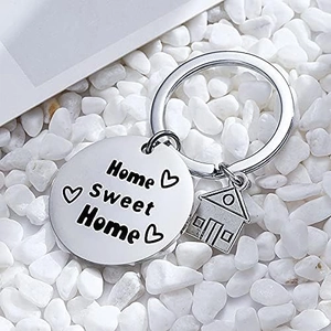 Stainless steel Home Sweet Home keychain with a house charm on white pebbles