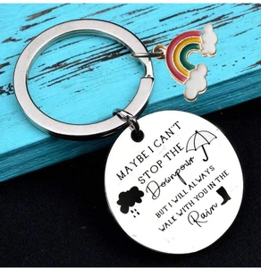 Detail of laser engraved quote and colorful rainbow charm on stainless steel keychain
