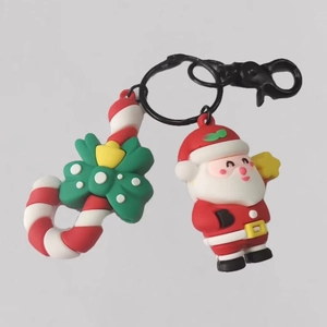 Simpatico portachiavi natalizio con Babbo Natale e ciondolo a forma di bastoncino di zucchero