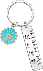 Detail of cute panda metal keychain with blue daisy charm and engraved text plate