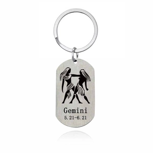 Detail macro view of Gemini stainless steel keychain with brushed metal finish and date