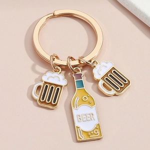 Close-up detail of golden beer mug and bottle enamel keychain with beer lettering