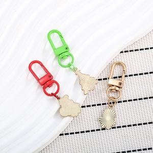 Detailed view of metal Christmas keychains with radial textures in gold, red and green