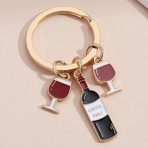 Macro shot of wine bottle keychain with Lafite 1982 engraving and red enamel glasses