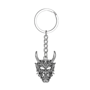 Dettaglio macro del portachiavi maschera fantasma Hannya con trame metalliche sbalzate