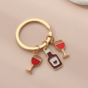 Detail view of gold alloy wine bottle and red wine glass charms on a premium keyring