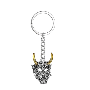 Dettaglio del portachiavi maschera Hannya vintage con corna dorate e catena argento