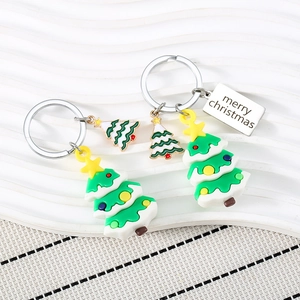 Cute PVC Christmas tree keychain set with metal tag and star detail on white surface