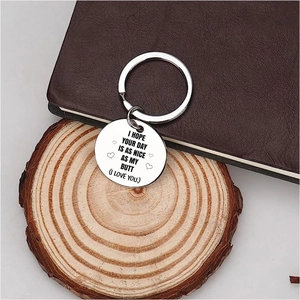 Détail macro du porte-clés cœur en acier inoxydable avec citation sur un dessous de bois