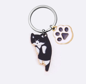 Detail of creative cartoon cat keychain with golden alloy ring and enamel cat paw charms