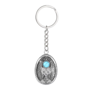 Detail of vintage silver eagle keychain with turquoise stone and Egyptian carvings