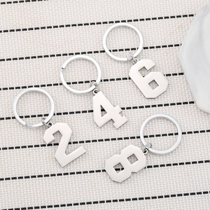 Polished silver stainless steel number keychains 2 4 6 8 on flatlay woven mat