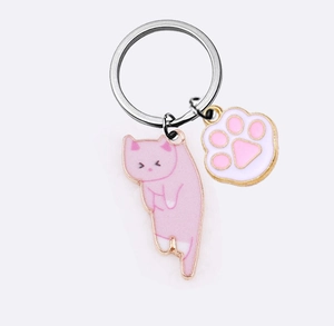 Detail of pink cartoon kitten and paw charm keychain made of smooth enamel and alloy metal
