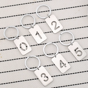 Polished stainless steel number keychains 0 to 5 for cars and backpacks on woven mat