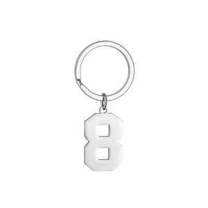 Close-up of polished silver metal number 8 pendant on a minimalist stainless steel keychain