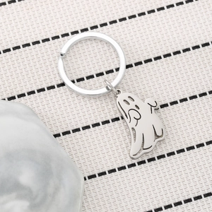 Cute cartoon ghost stainless steel keychain with polished finish on woven background