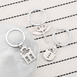 Christmas stainless steel keychain set with snowman and gift box charms on grey stone