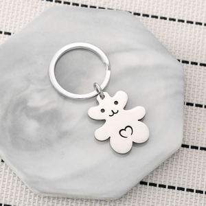 Porte-clés minimaliste en acier inoxydable ours avec cœur sur plateau marbre