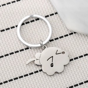Polished stainless steel anime keychain with cute cartoon character pendant on striped background