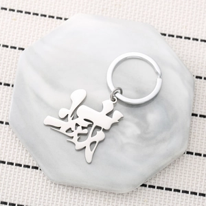 Stainless steel keychain featuring a stylized silver character on a marble display stand